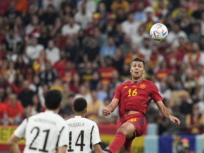 Španielsky hráč Rodri (vpravo) skáče za loptou