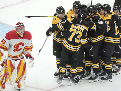 Brankár Calgary Dustin Wolf a oslavujúci hráči Bostonu Bruins