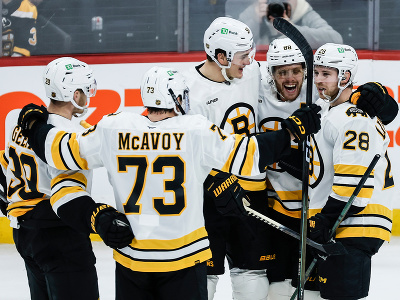 Jasajúci hokejisti Bostonu Bruins, vpravo Elias Lindholm, vedľa neho David Pastrňák