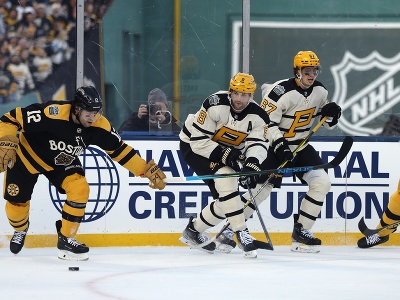 Hokejista Bostonu Craig Smith (12) a Brian Dumoulin (8) z Bostonu Bruins počas zápasu pod holým nebom NHL Winter Classic Boston Bruins - Pittsburgh Penguins v bostonskom Fenway Parku