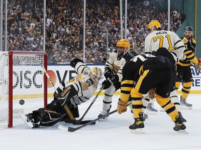 Brankár Tristan Jarry (35) z Pittsburghu Penguins vyráža puk pred hráčom Bostonu Jakeom DeBruskom počas zápasu pod holým nebom NHL Winter Classic Boston Bruins - Pittsburgh Penguins v bostonskom Fenway Parku