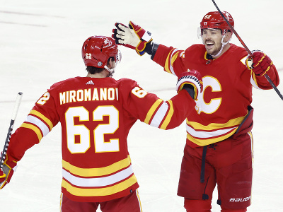 Hokejisti Calgary Flames Daniil Miromanov a MacKenzie Weegar oslavujú gól