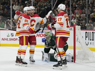 Hráči Calgary Flames oslavujú gól pred bránkou Minnesoty