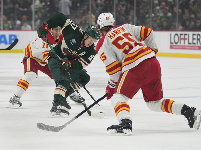 Kirill Kaprizov (Minnesota) sa snaží prejsť cez hráčov Flames