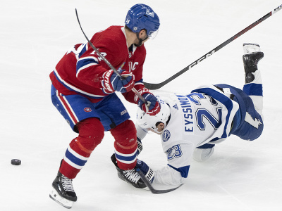 Michael Eyssimont padá na ľad, vedľa neho kapitán Canadiens Nick Suzuki