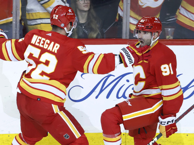 Hokejisti Calgary Flames Nazem Kadri a MacKenzie Weegar oslavujú gól