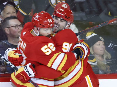 Hokejisti Calgary Flames Nazem Kadri a MacKenzie Weegar oslavujú gól