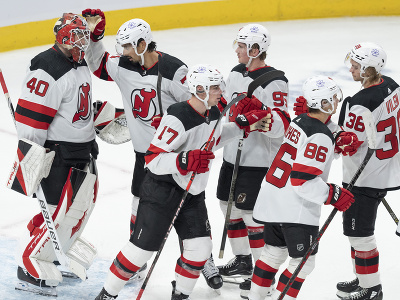 Hokejisti New Jersey Devils ďakujú brankárovi Akirovi Schmidovi po víťazstve v  prípravnom stretnutí proti Montrealu Canadiens, uprostred slovenský hokejista Šimon Nemec 