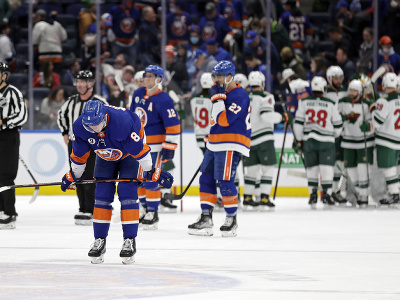 Smutní hráči New Yorku Islanders, v pozadí sa radujú hráči Minnesoty