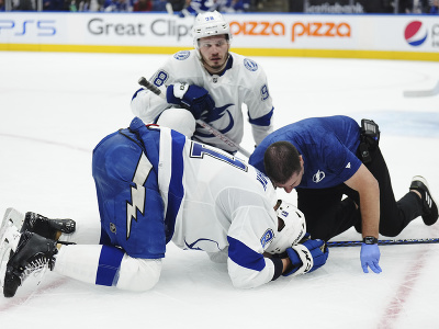 Erik Černák (Tampa Bay) leží na zemi po tvrdom zákroku od hráča Toronta