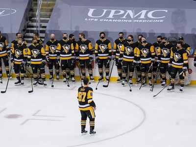 Sidney Crosby korčuľuje pred svojimi spoluhráčmi po tom, ako odohral 1000. zápas zámorskej hokejovej NHL 