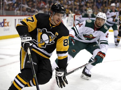 Sidney Crosby s pukom na hokejke, v pozadí obranca Minnesoty Matt Dumba
