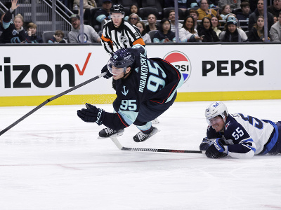 André Burakovsky (Seattle) padá na ľad po súboji s hráčom Winnipegu