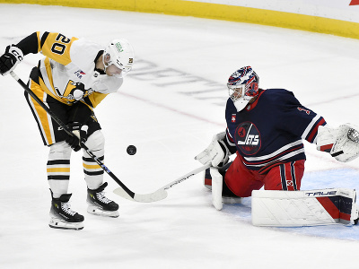 Brankár Jets Eric Comrie zasahuje pri šanci Larsa Ellera