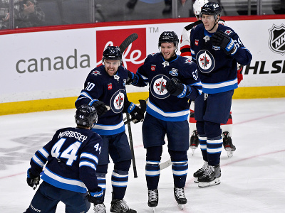 Gólové oslavy hráčov Winnipegu - zozadu Logan Stanley, Danny Zhilkin (53) a Tanner Pearson (70)