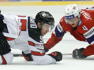 Hráč Kanady Connor McDavid (vľavo) a hráč Nórska Johannes Johannesen (vpravo) sledujú puk