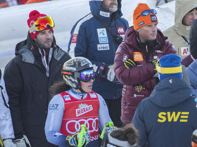 Na snímke vpravo hore tréner Mauro Pini sleduje ošetrovanie slovenskej lyžiarky Petry Vlhovej po páde počas prvého kola obrovského slalomu žien v rámci Svetového pohára v alpskom lyžovaní v Jasnej