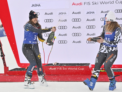 Na snímke švédska lyžiarka Sara Hectorová (vľavo) oslavuje so šampanským víťazstvo v obrovskom slalome žien v rámci Svetového pohára v alpskom lyžovaní v Jasnej 20. januára 2024. Vpravo Alice Robinsonová z Nového Zélandu