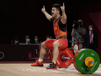 Na snímke čínsky vzpierač Š' Č'-jung triumfoval na XXXII. letných OH 2020  Tokiu v hmotnostnej kategórii do 73 kg v novom svetovom rekorde 364 kg v dvojboji a získal druhé olympijské zlato v kariére