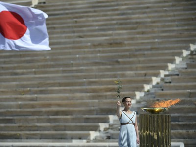 Choreografka a tanečnica Artemis Ignatiou stojí pri olympijskom ohni počas slávnostného odovzdania olympijského ohňa pre letné olympijské hry 2020  v Tokiu v Aténach.