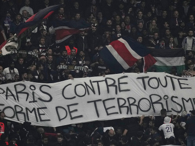 Futbaloví fanúšikovia držia transparent s nápisom 