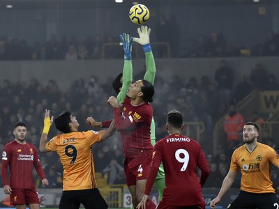 Brankár Liverpoolu Alisson (hore) bráni pred Raulom Jimenezom (uprostred vľavo) z Wolverhamptonu vo futbalovom zápase anglickej Premier League