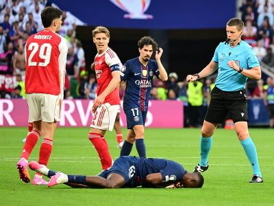 Na snímke hráč Paríža St. Germain (PSG) Willian Pacho leží na trávniku
