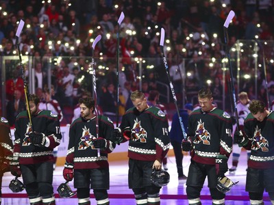 Richard Pánik (v strede) so spoluhráčmi dvíhajú hokejky počas minúty ticha v rámci boja proti rakovine - Hockey Fights Cancer.