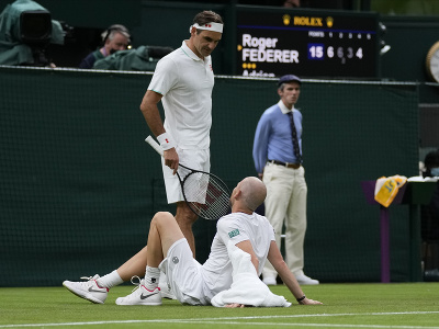 Zranený Adrian Mannarino sedí pri Rogerovi Federerovi