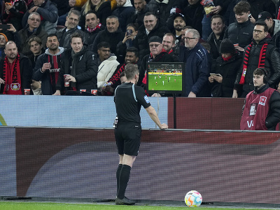 Rozhodca využíva systém VAR počas zápasu Bayeru Leverkusen s Bayernom Mníchov