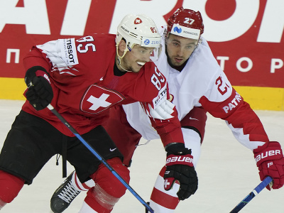 Švajčiarsky hokejista Sven Andrighetto (vľavo) a ruský hokejista Igor Ožiganov