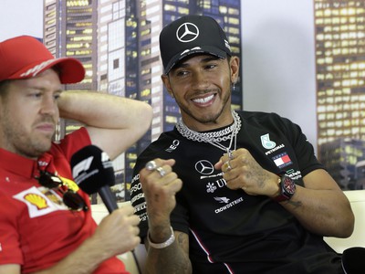Lewis Hamilton s úsmevom na tvári, vedľa neho Sebastian Vettel