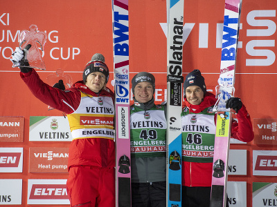 Slovinský skokan na lyžiach Anže Lanišek (uprostred) pózuje na pódiu po triumfe v súťaži Svetového pohára vo švajčiarskom stredisku Engelberg 