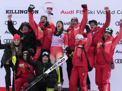 Švajčiarska lyžiarka Wendy Holdenerová (uprostred) oslavuje na pódiu so svojím tímom po triumfe