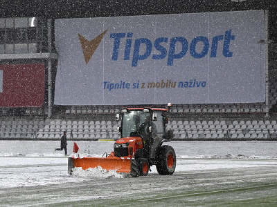 Traktor odhŕňa sneh z hracej plochy po tom, čo hlavný rozhodca v 20. minúte prerušil zápas pre nespôsobilý terén