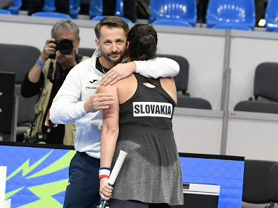 Zľava nehrajúci kapitán Matej Lipták a slovenská tenistka Viktória Hrunčáková sa objímajú po výhre nad Slovinkou Veronikou Erjavečovou po druhej dvojhre