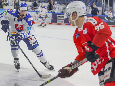 Na snímke zľava slovenský hokejista Samuel Takáč a Švajčiar Tyler Moy bojujú o puk