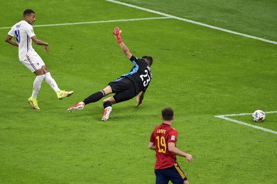 Francúzsky futbalista Kylian Mbappé prekonáva španielskeho brankára Unaia Simona