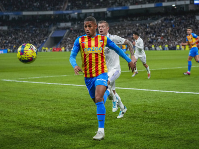 Hráč Valencie Samuel Lino (vpredu) uteká za loptou vedľa Toniho Kroosa z Realu Madrid