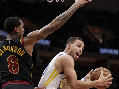Hráč Goldenu State Warriors  Stephen Curry (vpravo) strieľa na kôš cez Jordana Clarksona z Clevelandu Cavaliers