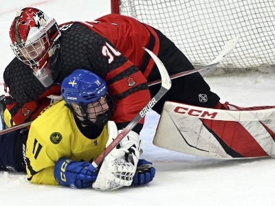 Brankár Kanady Carter George a hokejista Švédska Lucas Pettersson bojujú pred bránou