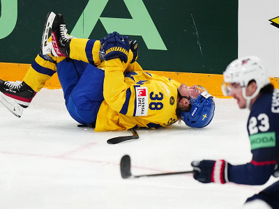 Švédsky hokejista Rasmus Sandin sa skrúca v bolestiach po súboji s Američanom Michaelom Eyssimontom (vľavo)
