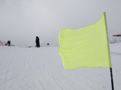 Na snímke žltá zastávka veje vo vetre na svahu vo švajčiarskom lyžiarskom stredisku  Zermatt v nedeľu 19. novembra 2023. Pre silný vietor v nedeľu zrušili aj druhý zjazd Svetového pohára alpských lyžiarok v Zermatte