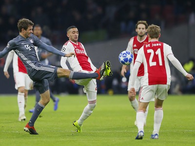 Hráč Bayernu Thomas Müller (vľavo) bojuje o loptu s Hakimom Ziyechom (uprostred) z Ajaxu
