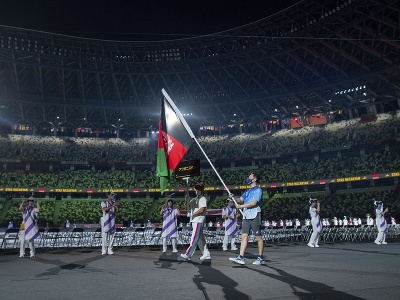 Dobrovoľník nesie afganskú vlajku počas otváracieho ceremoniálu paralympijských hier v Tokiu
