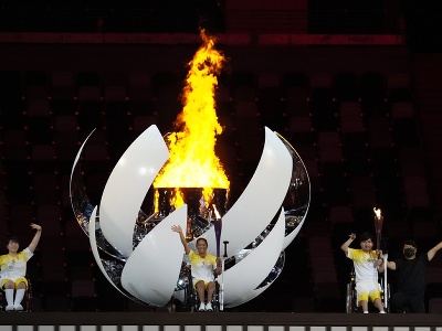 Športovci mávajú po zapálení Paralympijského ohňa počas otváracieho ceremoniálu paralympijských hier v Tokiu