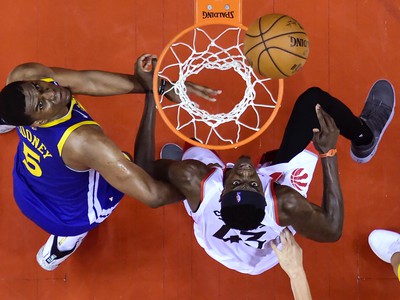 Na snímke vpravo hráč Raptors Pascal Siakam, vľavo hráč Warriors Kevon Looney v zápase finále basketbalovej NBA 
