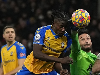 Na snímke sprava brankár Tottenhamu Hugo Lloris vyráža loptu, vľavo hlavičkuje ghanský obranca Southamptonu Mohammed Salisu