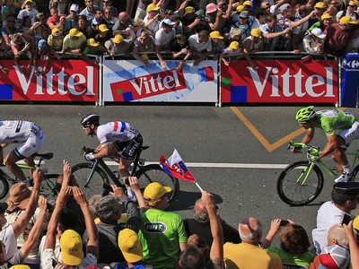 Šprint v 10. etape Tour de France. Petrovi Saganovi fandí i ruka so slovenskou vlajkou, pred ním zlý muž pretekov Mark Cavendish
