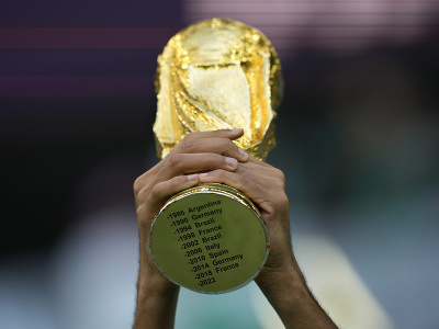 Fanúšik drží imitáciu trofeje pre víťaza MS vo futbale